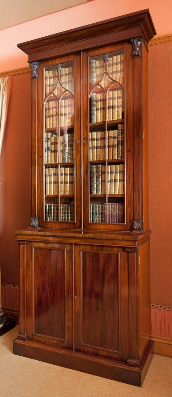A William IV period tall mahogany and glazed door Bookcase with gothic arched astragals below deeply moulded cornice and over two-door cupboard base. Fine quality stylised foliate detailing to the finials, capitals and bases. Excellent colour.