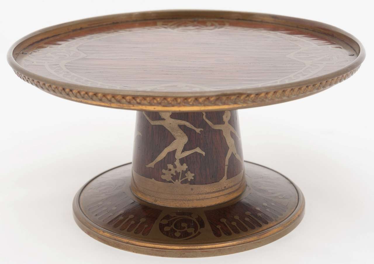 A fine Art Nouveau period rosewood tazza inlaid with brass decoration of formal borders and dancing figures. 

Provenance: Base stamped 