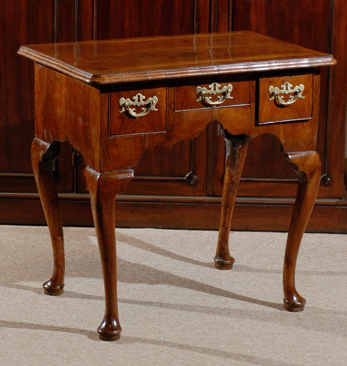 A Walnut Lowboy with Three Drawers, Cross-banded Top, Shaped Apron and Cabriole Legs terminating in Pad Feet - dating from the first quarter of the 18th Century and English in origin.

TO SEE ALL OF OUR INVENTORY PLEASE VISIT OUR