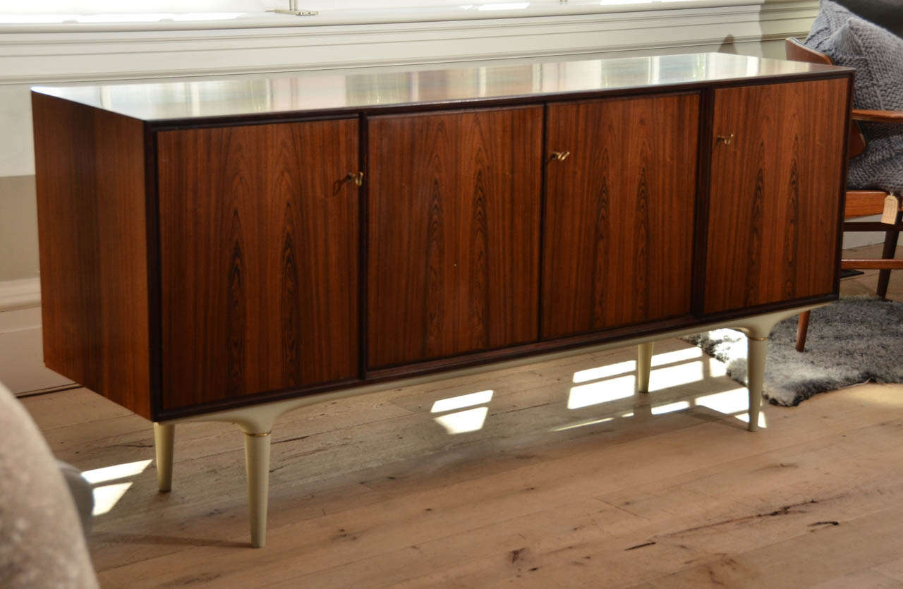 Beautiful Mid-Century Scandinavian rosewood credenza in the Style of Gunni Omann with contrasting white legs.
