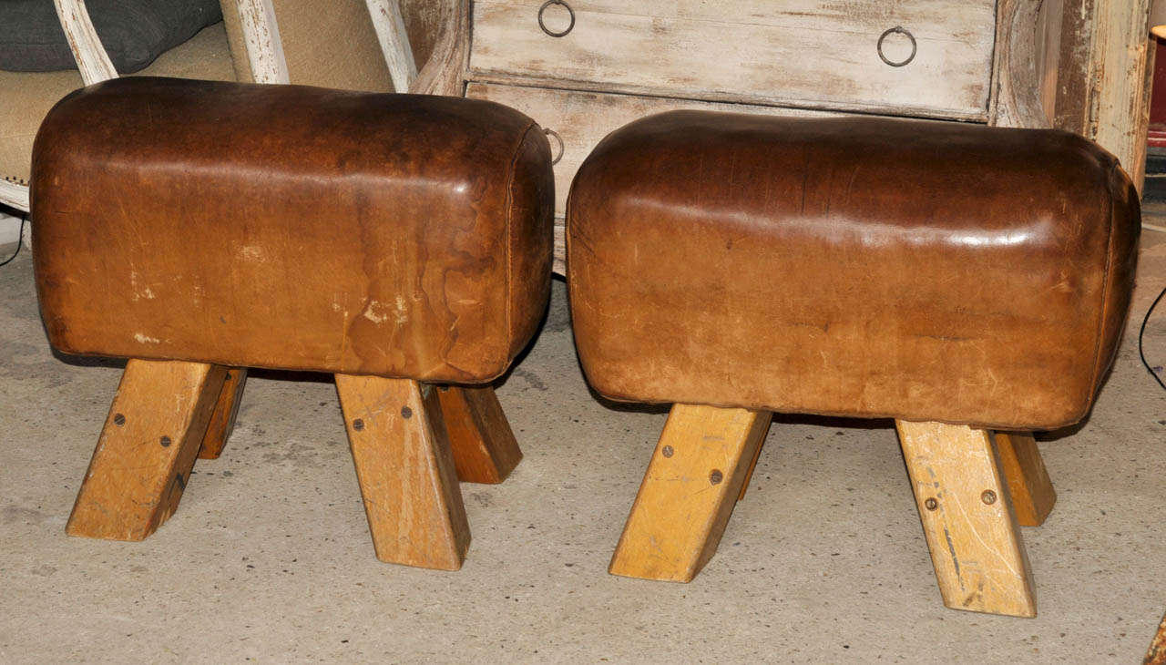 Pair of 1970-1980's bland wood and leather stools. Marks of wear. Good condition. Normal wear consistent with age and use.