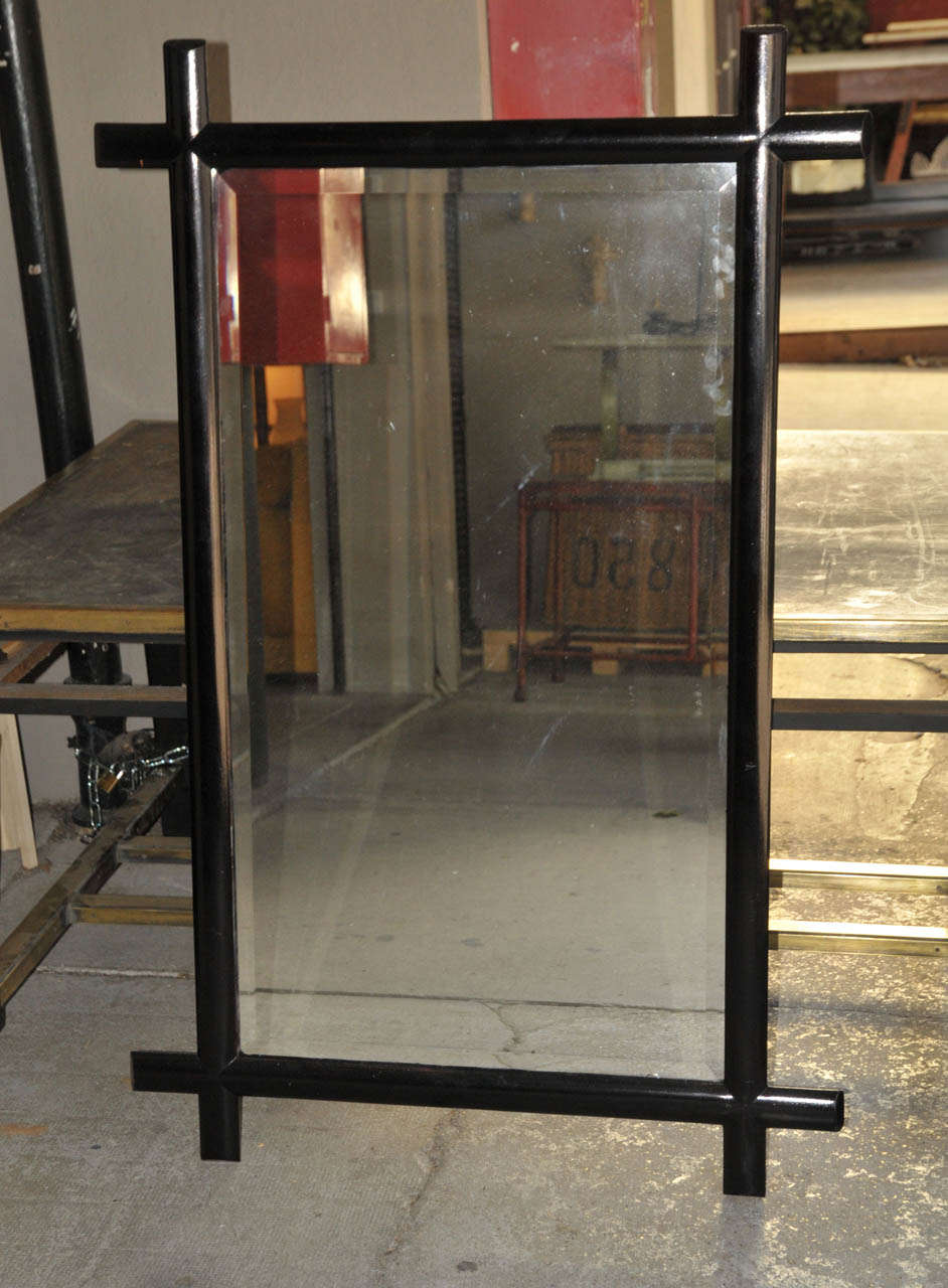 Pair of large 1960's Italian wall mirrors in black lacquered mahogany. Beveled mirror. Wood panel back. One impact on one mirror bottom. Good condition. Normal wear consistent with age and use.
