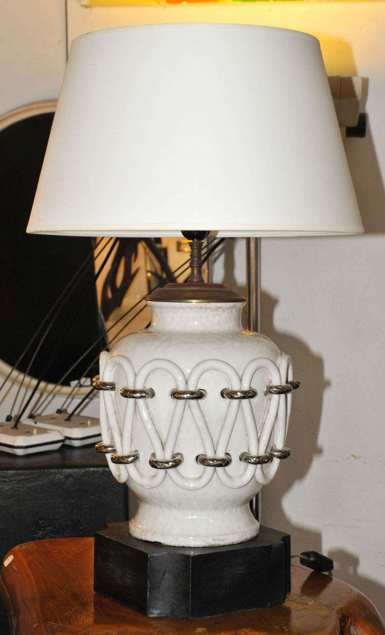 1950's white enameled ceramic table lamp. Ebonized wood base. New shade. Wired for European use. Very good condition. Normal wear consistent with age and use. 

Dimension with shade: Height 65cm x Diameter 40cm.
Dimension without shade: Height