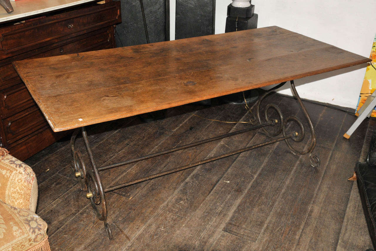 1940's wrought iron coffee table with a solid oak top. Few stains and some burning marks on the top. Good condition. Normal wear consistent with age and use.