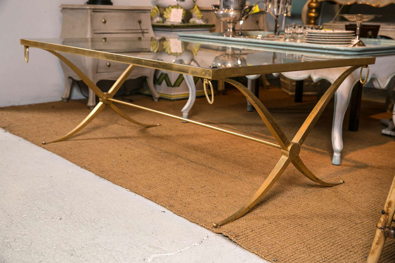 Elegant X form base in gilded iron with glass top.