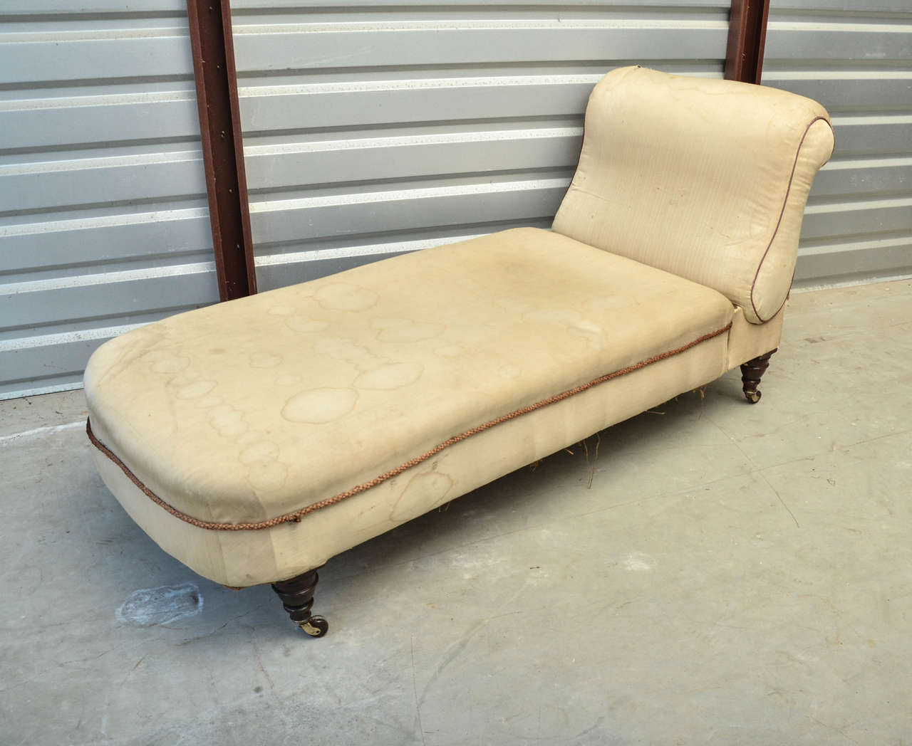 English Victorian ratchet back chaise longue. The chaise sits on four mahogany turned tapering legs on brass castors with brown ceramic wheels. The back has a brass recessed handle that releases the back to lay nearly flat, making it a great place