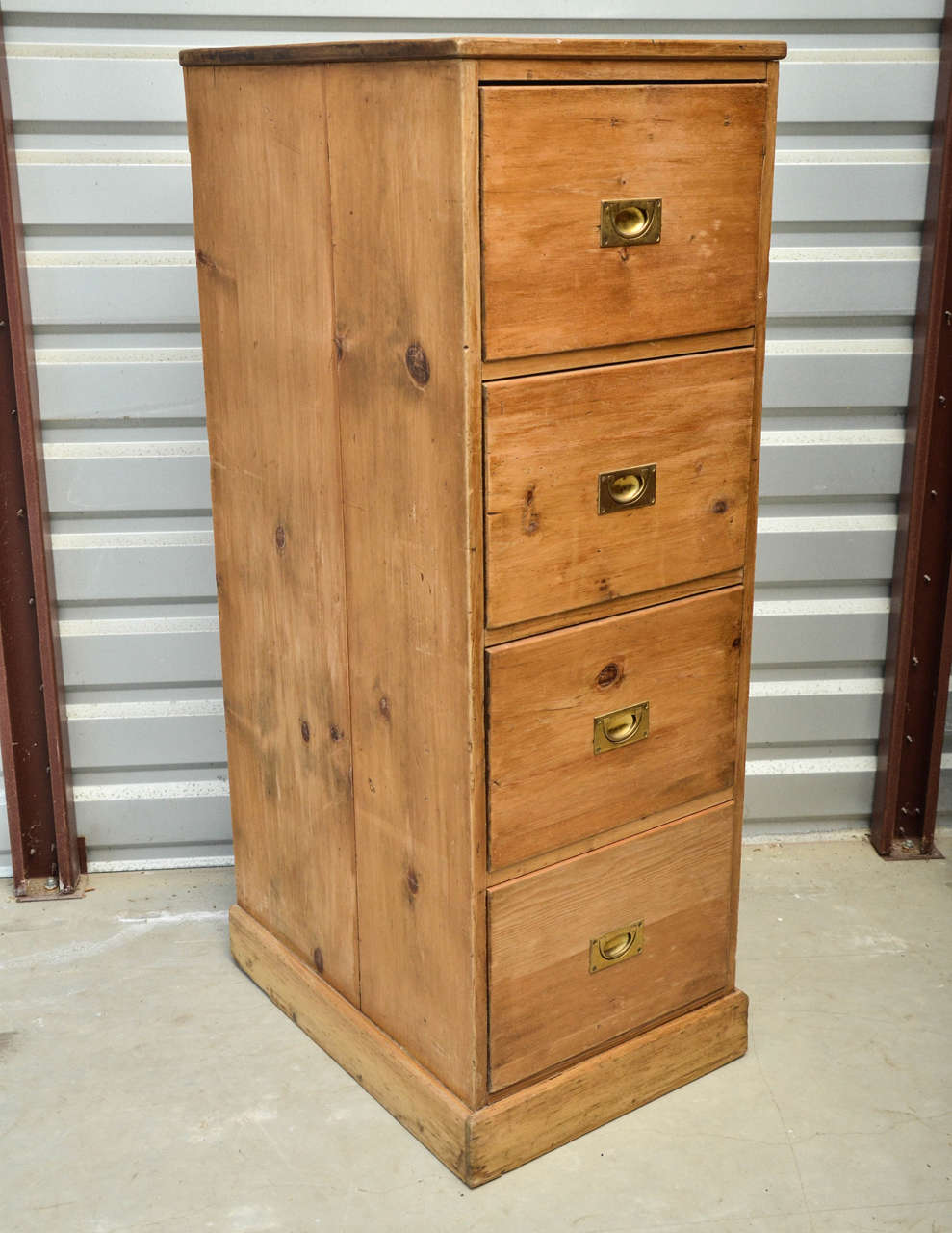English Edwardian four-drawer pine file cabinet with four dovetailed drawers, having recessed brass Campaign pulls. Each drawer has a sliding file divider. Great as intended for files, toys or any other kind of storage.