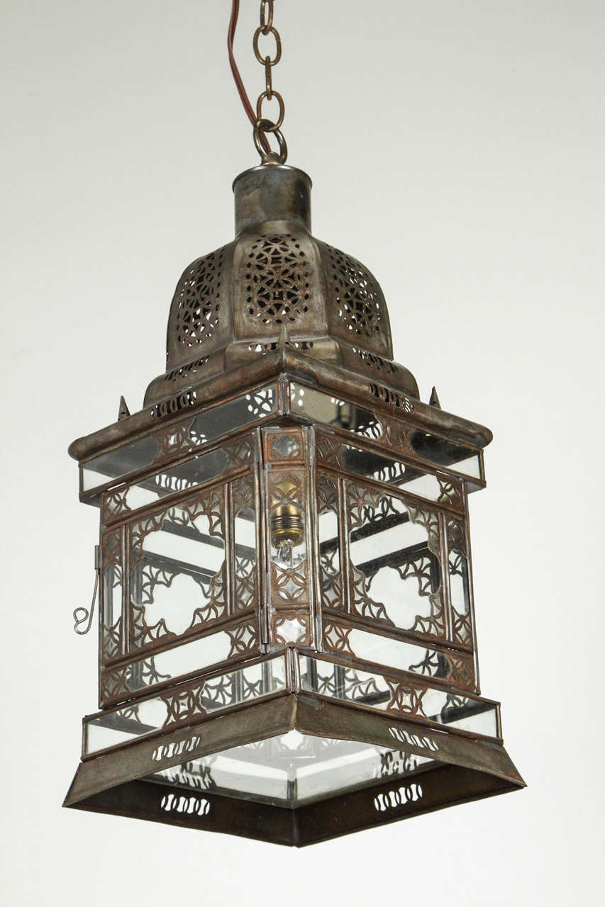Moroccan hanging clear glass lantern with very nice intricate filigree metal work.
Handcrafted in Marrakech Morocco by artisans.
Wired with one light socket max light bulb: 60 watts.