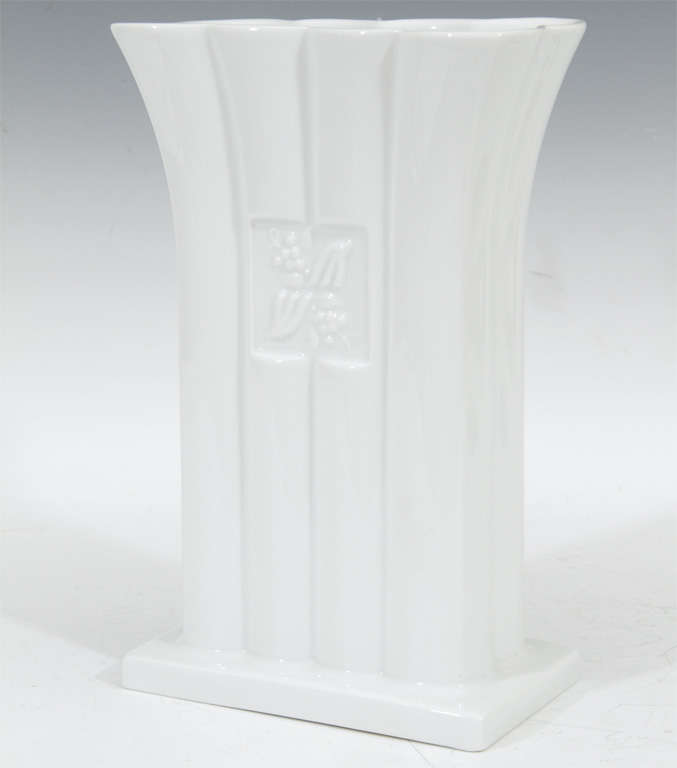 A trumpet mouth, fluted rectangular vase by influential architect and designer Michael Graves. The piece mimics elements of classical Greek architecture; a fluted column sitting on the stylobate base typical among greek temples. The piece has a