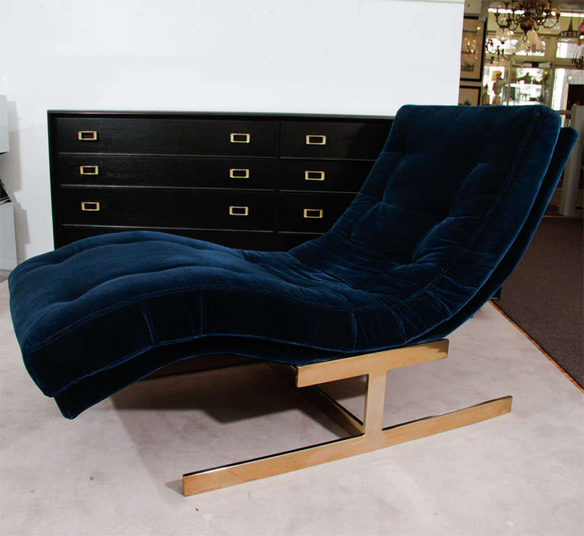 A wave form chaise in original, tufted blue velvet upholstery with brass base. By esteemed designer Milo Baughman.