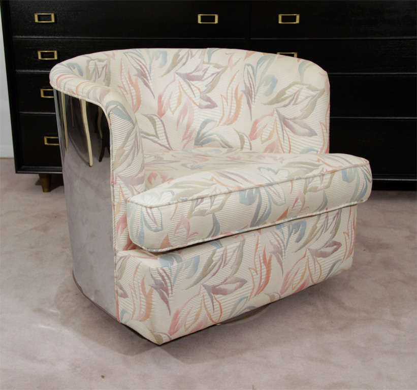 A pair of barrel back swivel chairs by Milo Baughman for Thayer Coggin. The backs are of wrapping chrome