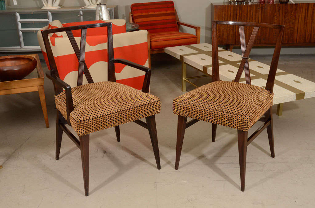 Six dining chairs in dark walnut by Tommi Parzinger. A classic Parzinger form, recently upholstered in Old World Weavers fabric. Four sides and two arms.