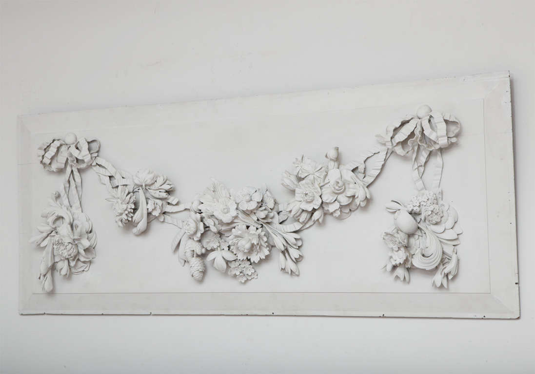 A large white wood panel with hand-carved floral high-relief, attributed to Grinling Gibbons, early 18th century.