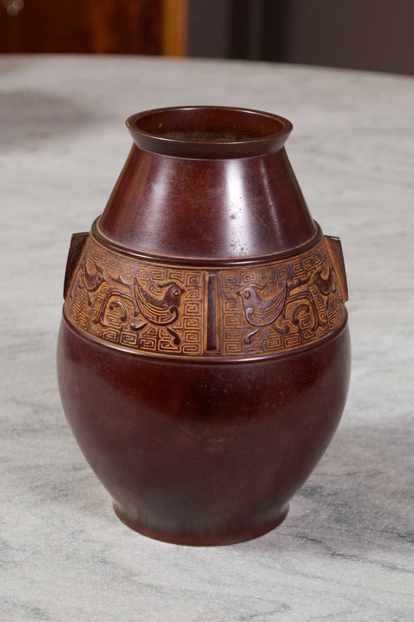 A bronze vase with a quail frieze and small handles.  Unmarked