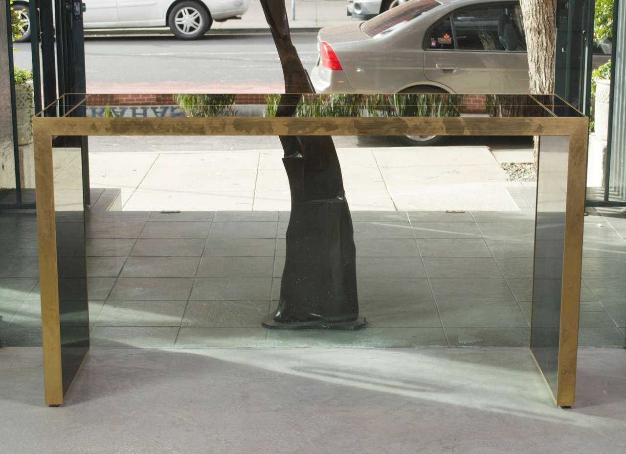 Beautiful hand crafted black mirrored parson style console, broken into rectangular segments and trimmed in brass.