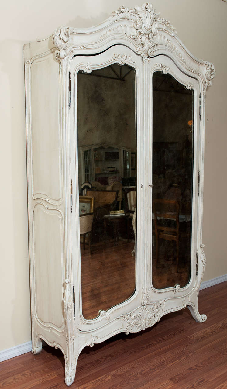 Beautiful Louis XV style hand carved armoire with mirror doors.
Extensive carving on the crown and base of the armoire.
The mirrored doors are original.