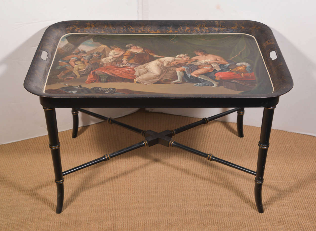 Continental tole tray on stand of rectangular handled form, tray decorated with polychrome classical figures on black ground, on ebonized wood stand.