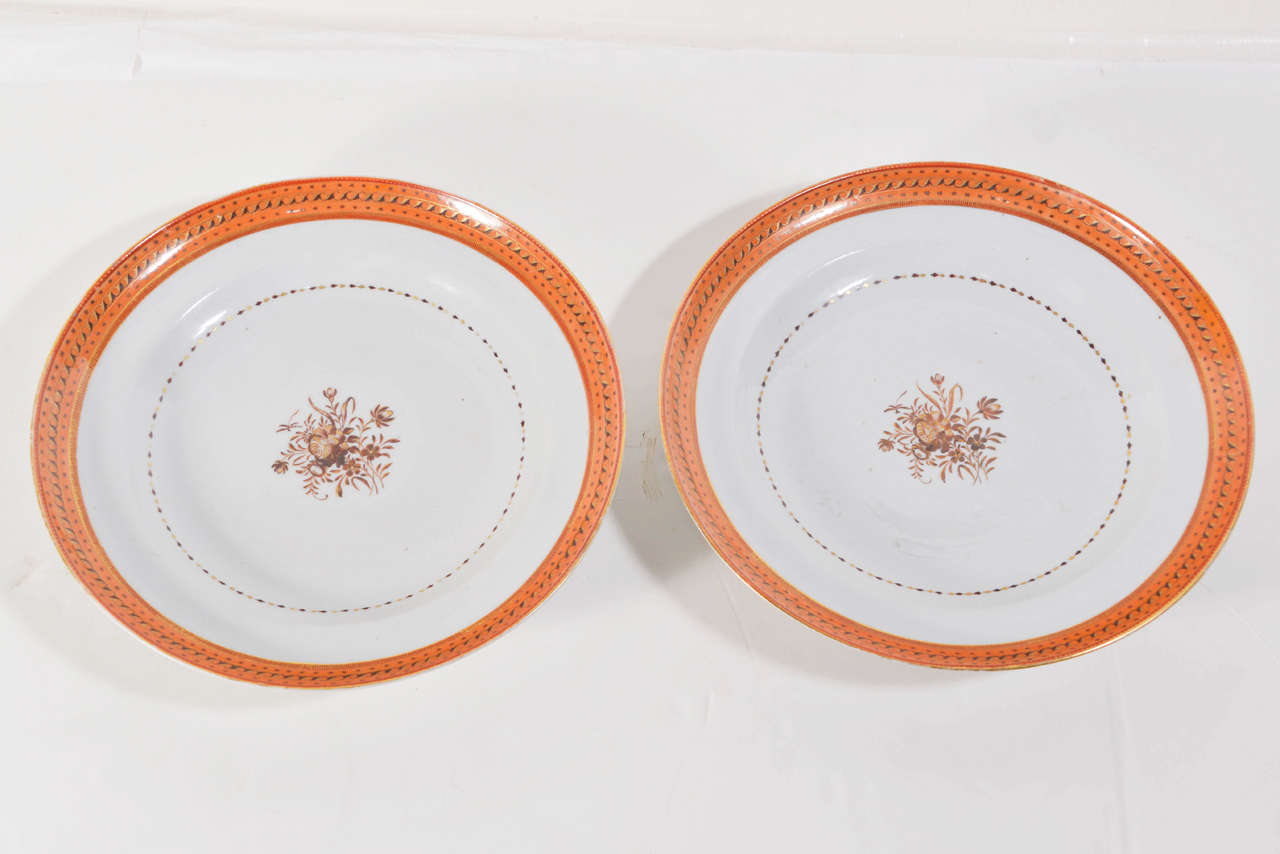 Pair of 19th c. Chinese export porcelain plates.  Creme ground banded in orange and gold, cenetered with a brown and gilt floral spray.  Border of scrolling leaves and stars.