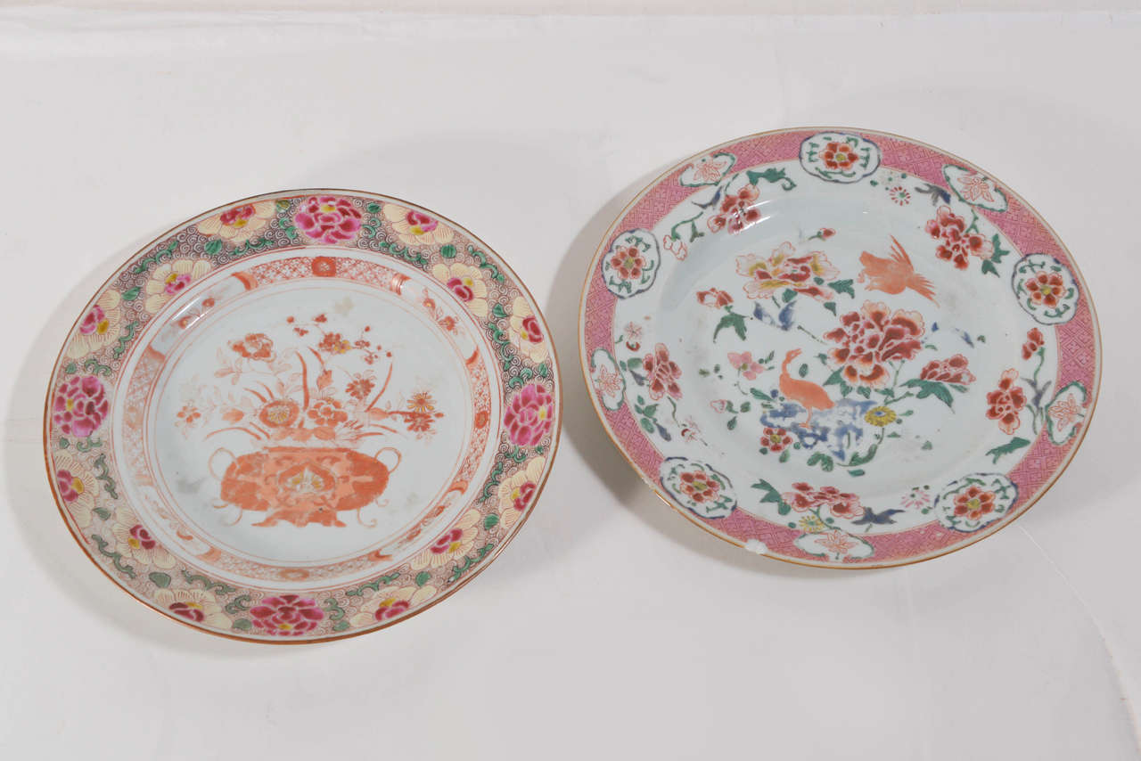 Companion pair of Chinese export porcelain plates, both bordered with floral and foliate motif. White ground with prominent colors of coral, pink and green.