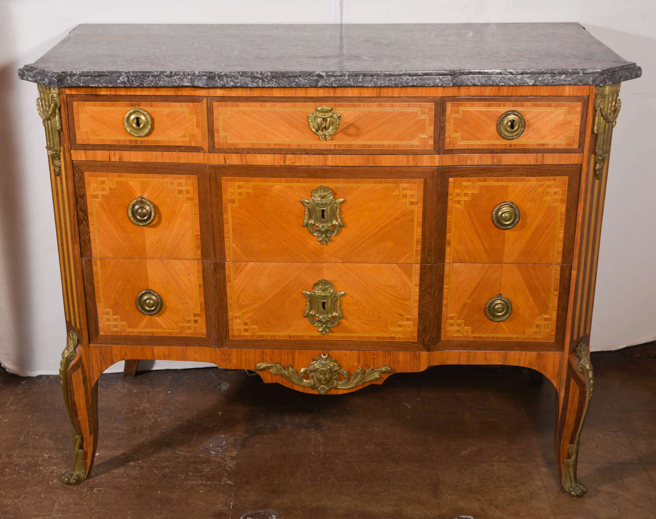 Transitional Louis XV-XVI period marquetry commode with grey marble top. Three upper drawers over two lower drawers. Ormolu mounts. Circa 1770. This is not a set of two.