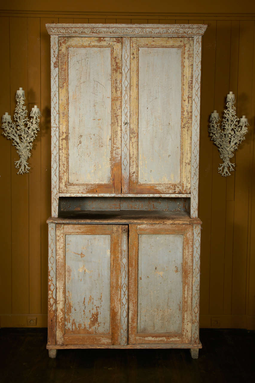 Swedish Gustavian period painted tall cupboard, retaining most of its original first two painted colors. Beautifull carved details. And unusual proportion beacuse very tall for this type of piece. Rare display in the lower part, left door is