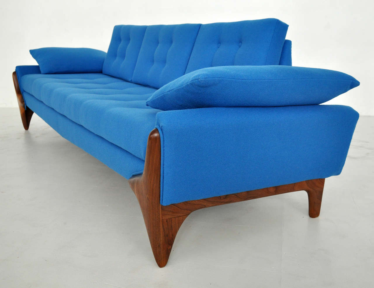 Sculptural Adrian Pearsall sofa.  Solid walnut bases with beautiful wood grain.  Newly upholstered in vibrant blue wool.