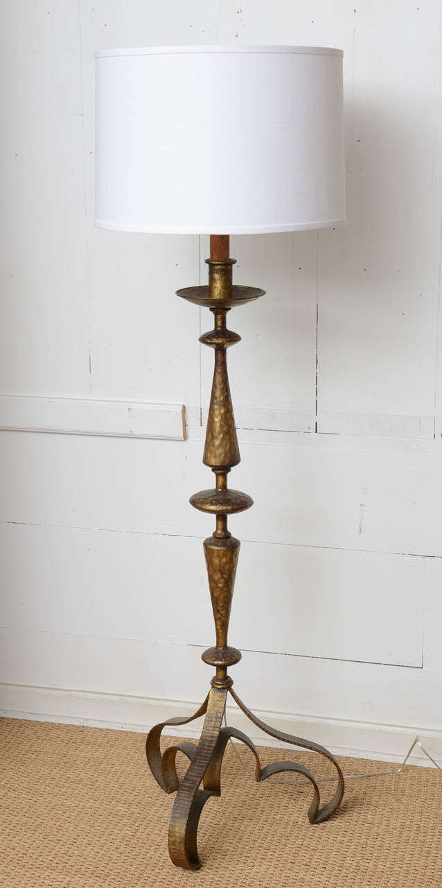 Dramatically curvy worn gilt iron floor lamp