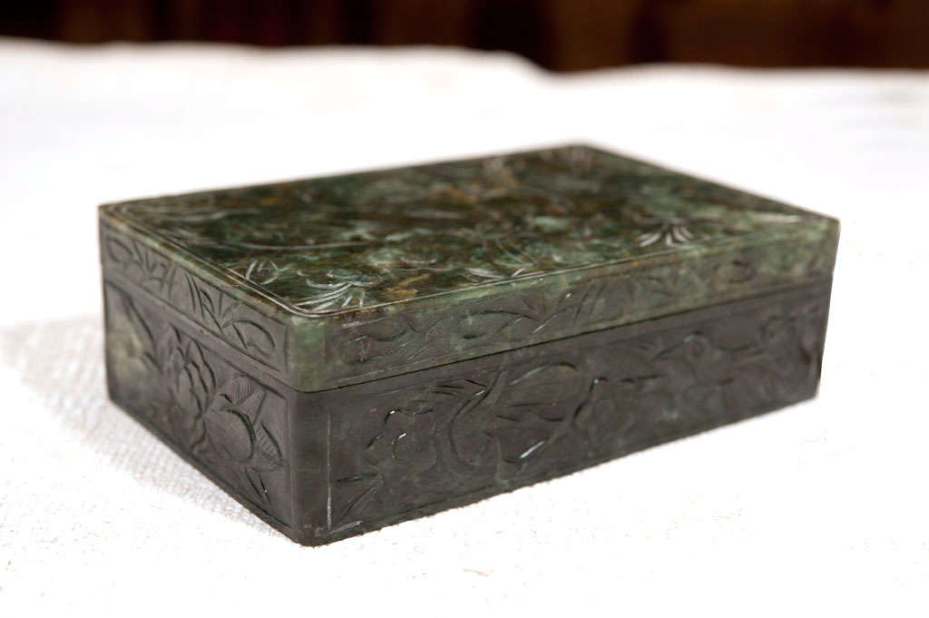 The box is made out of carved green Jade, semiprecious stone.  
There are birds and leafs on the five sides of the box. It was used for holding ink during the Ming Dynasty in ancient China.