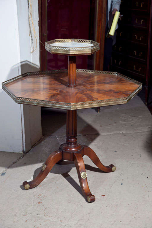Jansen two-tier octagonal table with a white marble top supported by a quad pod pedestal base. Both shelves with pierced gallery. Bronze mounts.