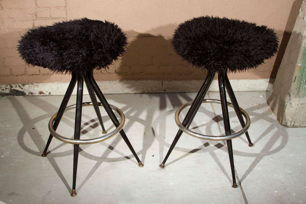 Mid-century bar stools with original black faux long pile fur upholstery with brass atomic 4-legged base.