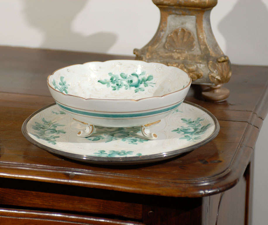 A French Limoges porcelain bowl from the late 19th century, with green bouquet of roses décor, petite gilt feet and matching underplate. Created by the AMR factory (Ancienne Manufacture Royale) during the last quarter of the 19th century, this