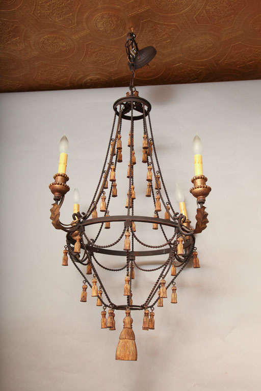 Chandelier, of iron, in basket shape, having gilded iron tassels on  all supporting "ropes," four candlearms with acanthus leaf details.