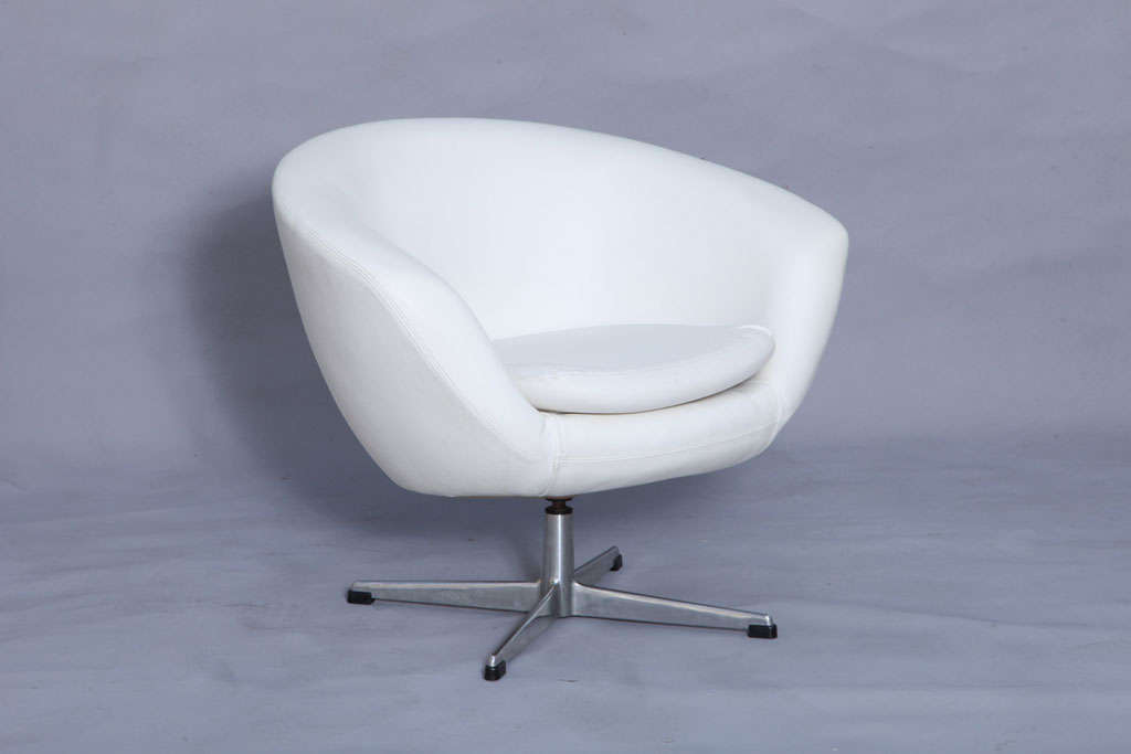 A pair of Overman swivel tub chairs, each in original white vinyl upholstery on polished aluminum four-point bases.