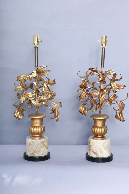 Pair of lamps, each a giltwood fluted urn filled with spiraling leaves of gilded iron, raised on faux painted round metal plinth.

Stock ID: D8340