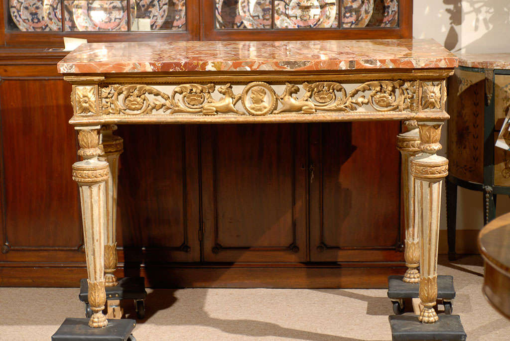 An Neoclassical Italian painted and parcel gilt console w/inlaid marble  on stone top, Roman bust medallion with flanking sphinx detail on frieze and circular fluted legs. 

For many more fine antiques, please visit our online gallery including