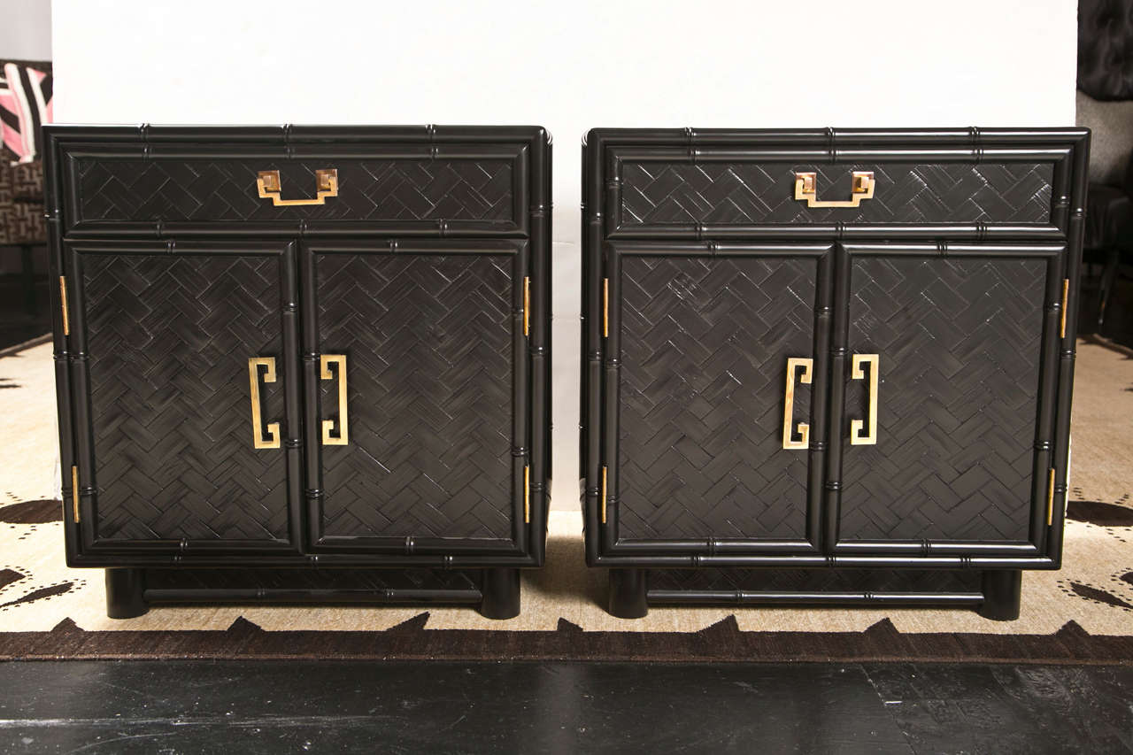 Vintage faux bamboo side tables/nightstands recently refinished in black.  Lower open section with two doors, drawer above. Woven rattan with bamboo framing, exceptional Chinoiserie style brass hardwares