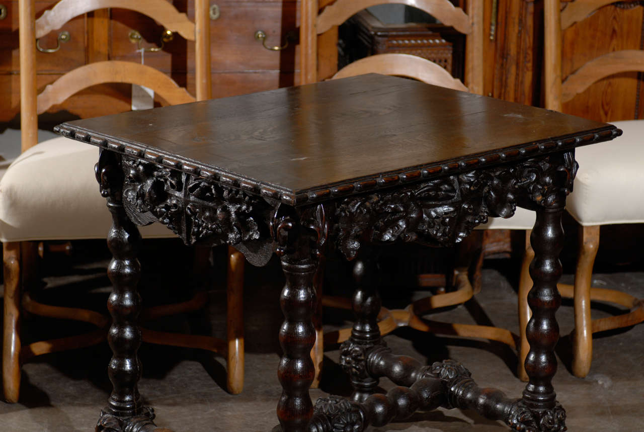 This German Black Forest side table / desk from the late 19th century features a rectangular top with molding. The top sits on a richly carved apron, adorned with foliage motifs. The front section has an exquisite single drawer, which opens up to