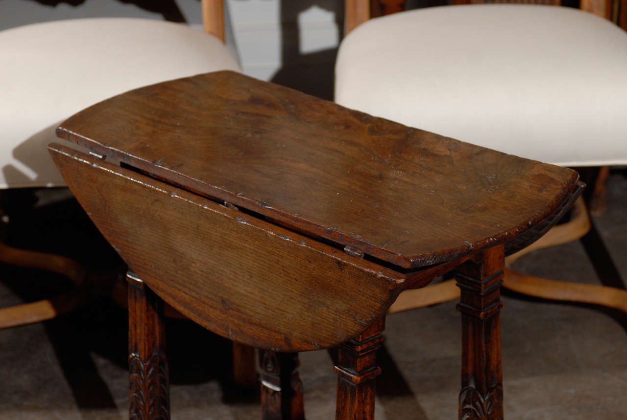 English drop leaf side table with stretcher and carved legs.