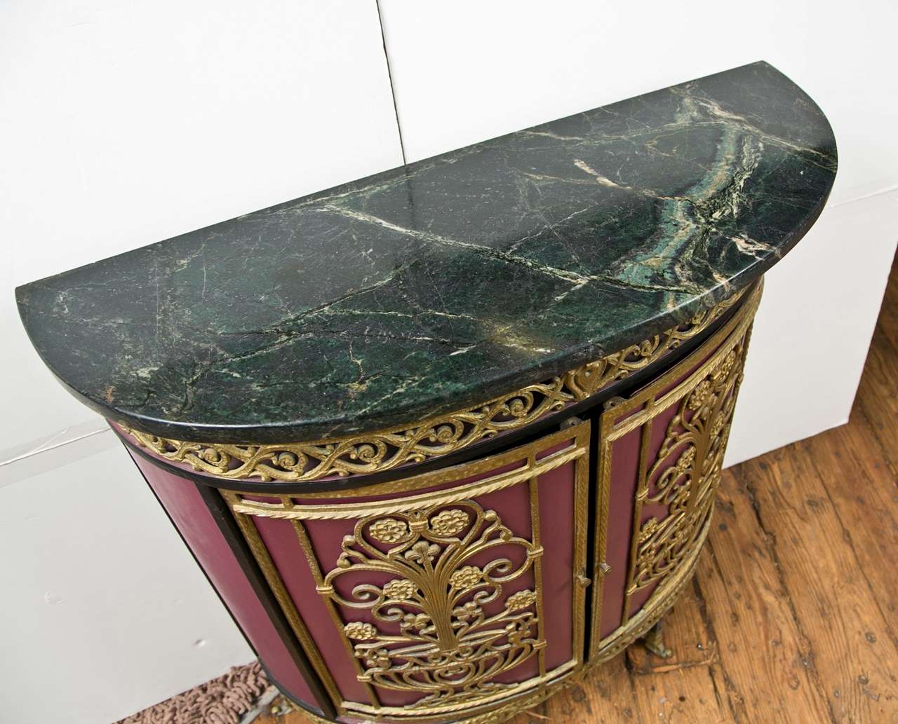 Oscar Bach designed and made this cabinet in 1920 in Sweden.  It is made completely of iron with appliques of bronze. The iron is enameled dark red. The marble top is green/black and called Swedish Green Marble- Center shelf inside.  Very Unique