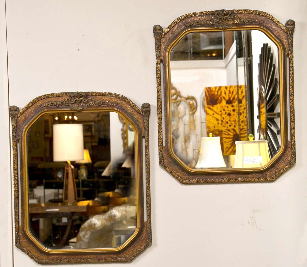 A pair of gilt gold wooden wall mirros. Each having a central mirror frames in gilt carved gold frame both with open sides.