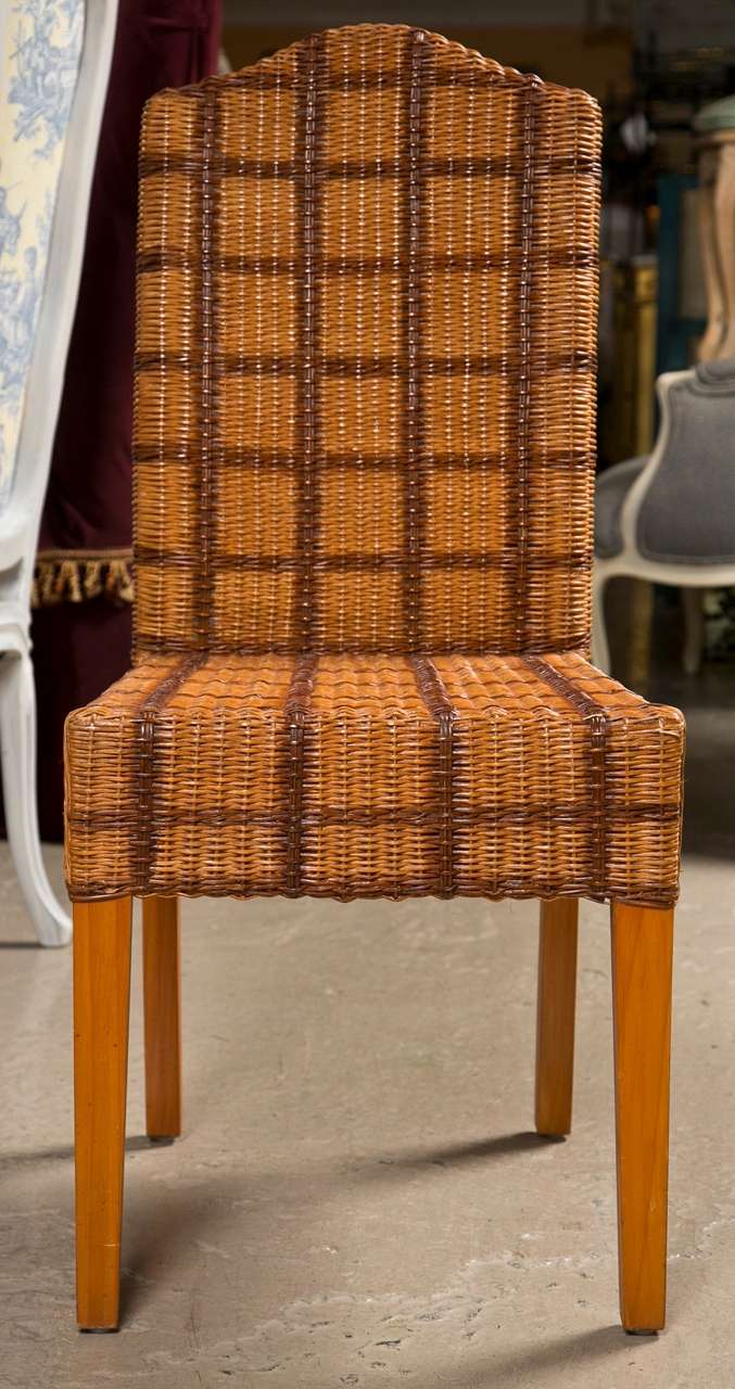 Set of four Palelek Wicker side chairs. Each having a yew color leg leading to a solid wicker tweed decorated seat and back.