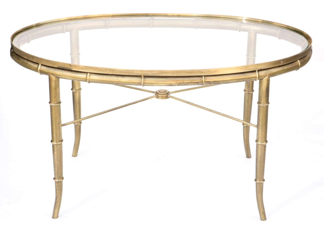 Regency style brass faux bamboo oval end table with glass top.