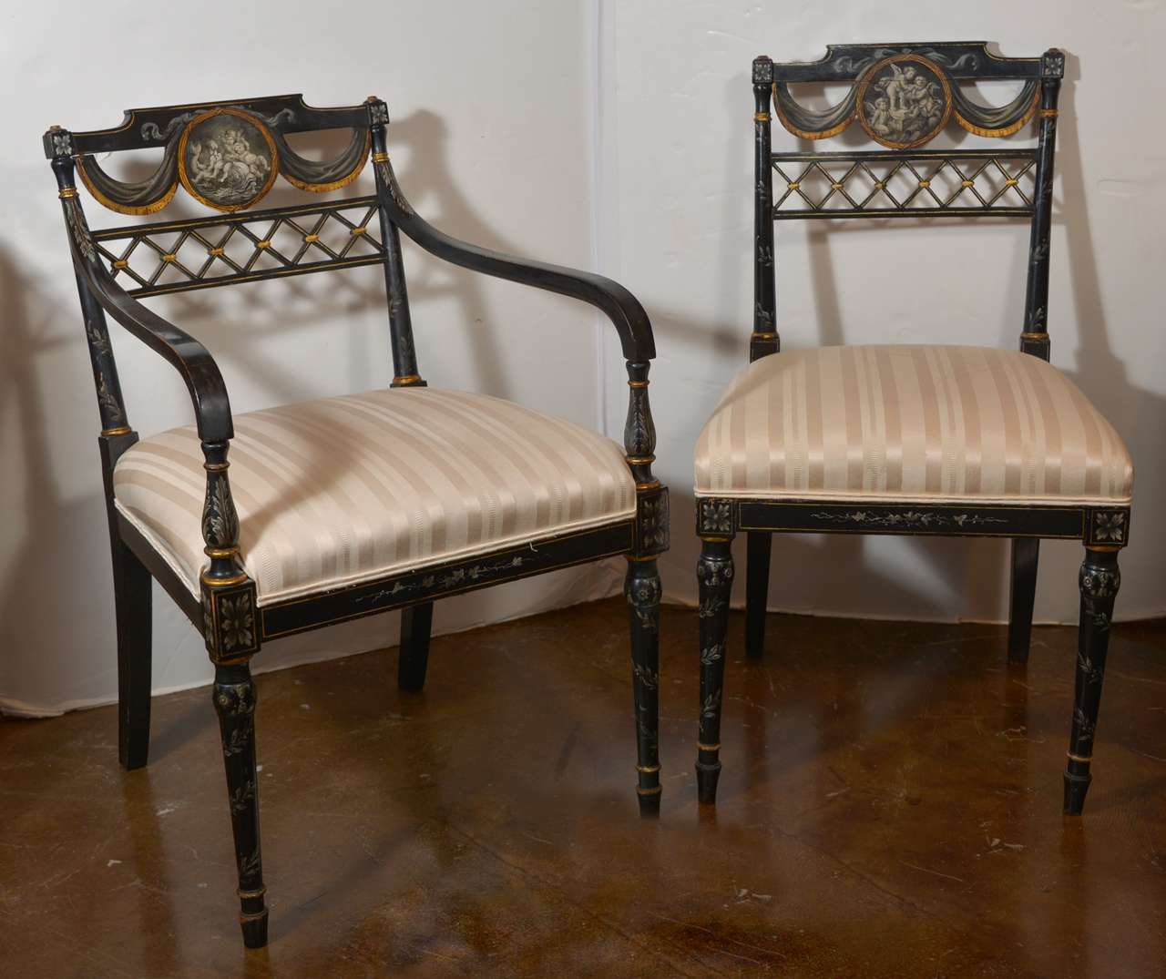 Set of six Englsh Regency black lacquered chairs two arms and 4 sides. Original Griselle painted scenes of cherubs at play .