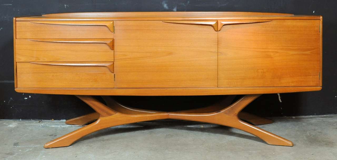 Stunning and very rare sideboard by top level furniture maker Beithcraft, from the Scotch village of Beith. Amazingly well designed organically shaped sideboard. It has 2 swingingdoors with a shelf behind and 3 drawers of which one cutlery drawer