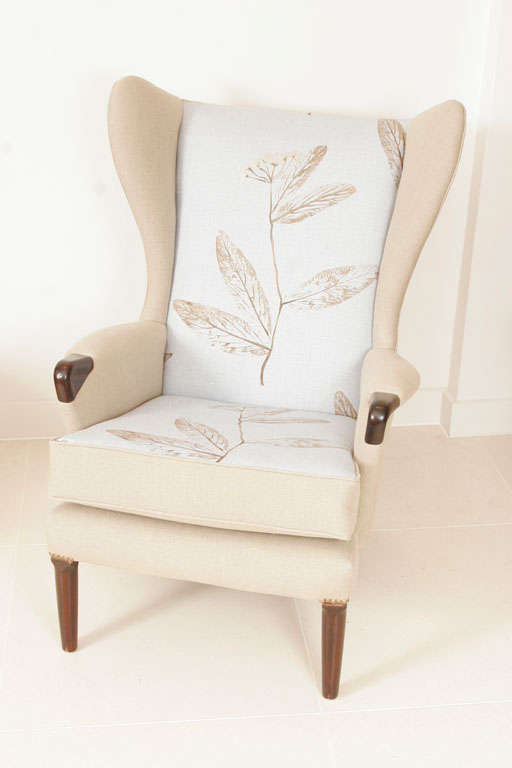 Upholstered in 'Leaf' patterned cream and light blue cotton, with dark wood detailing to feet and arms.