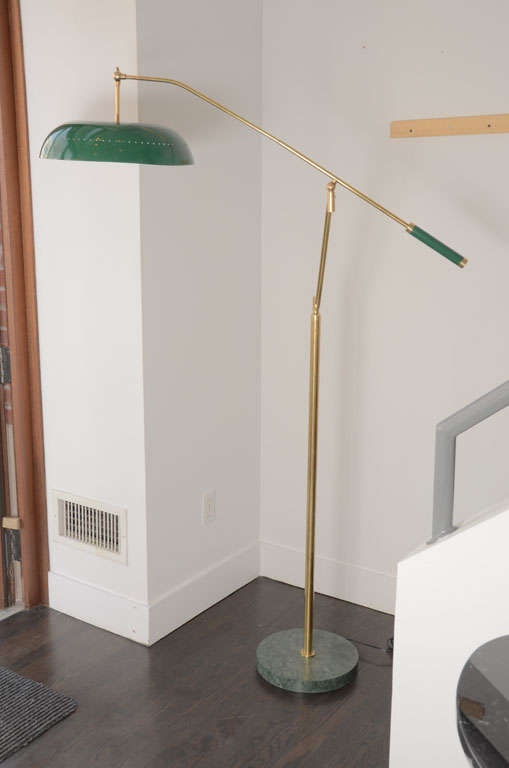 Italian adjustable floor lamp in the style of Stilnovo.

An adjustable brass pivot arm connected to a swivel stem standing on round green marble base.