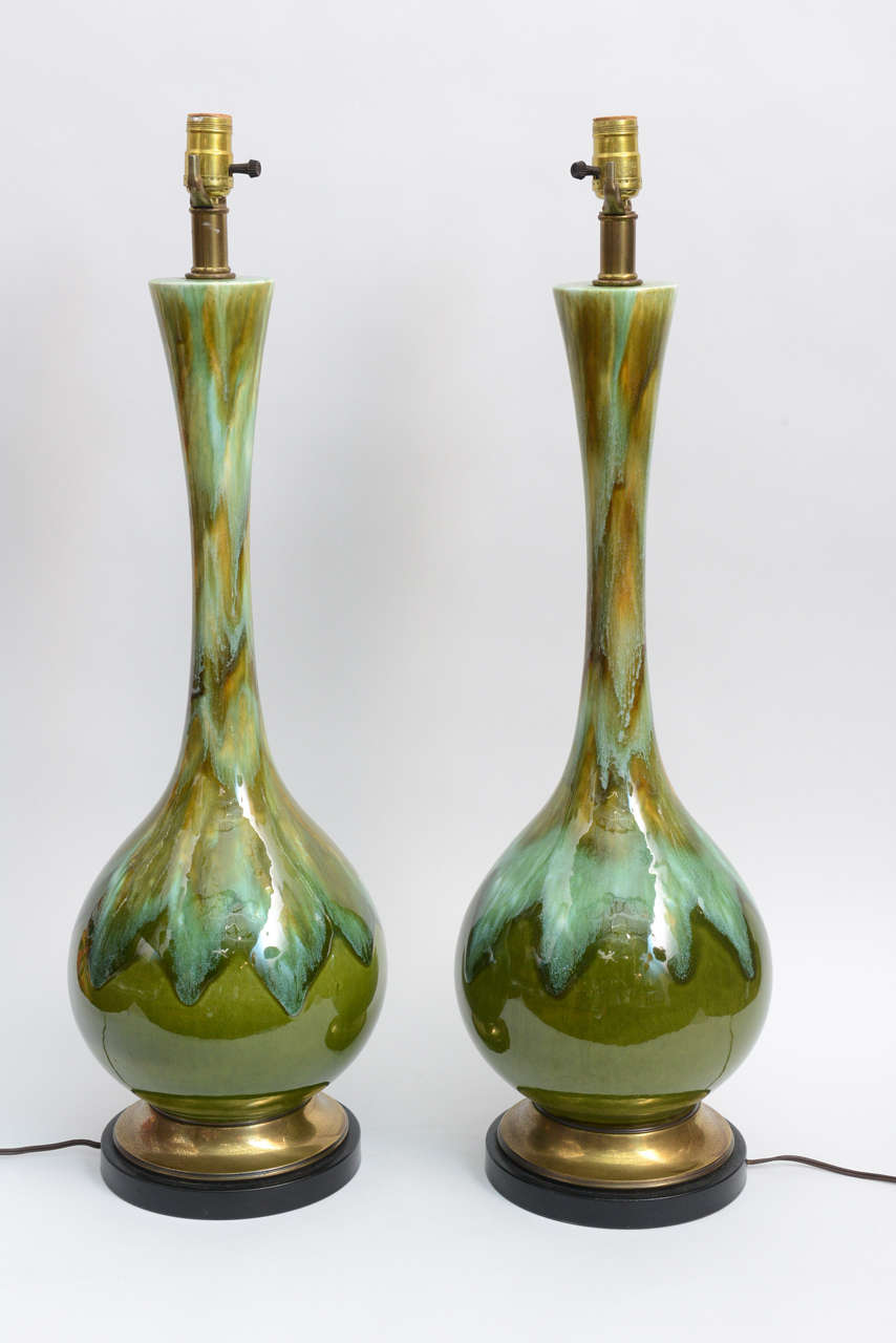 These two stunning lamps will catch the eye of all your guests.  Long, elegant lines shape these quintessentially mid-century lamps.  Beautiful opalescent blues and a touch of orange seem to drip down over an avocado green.  Lamp bases are matte