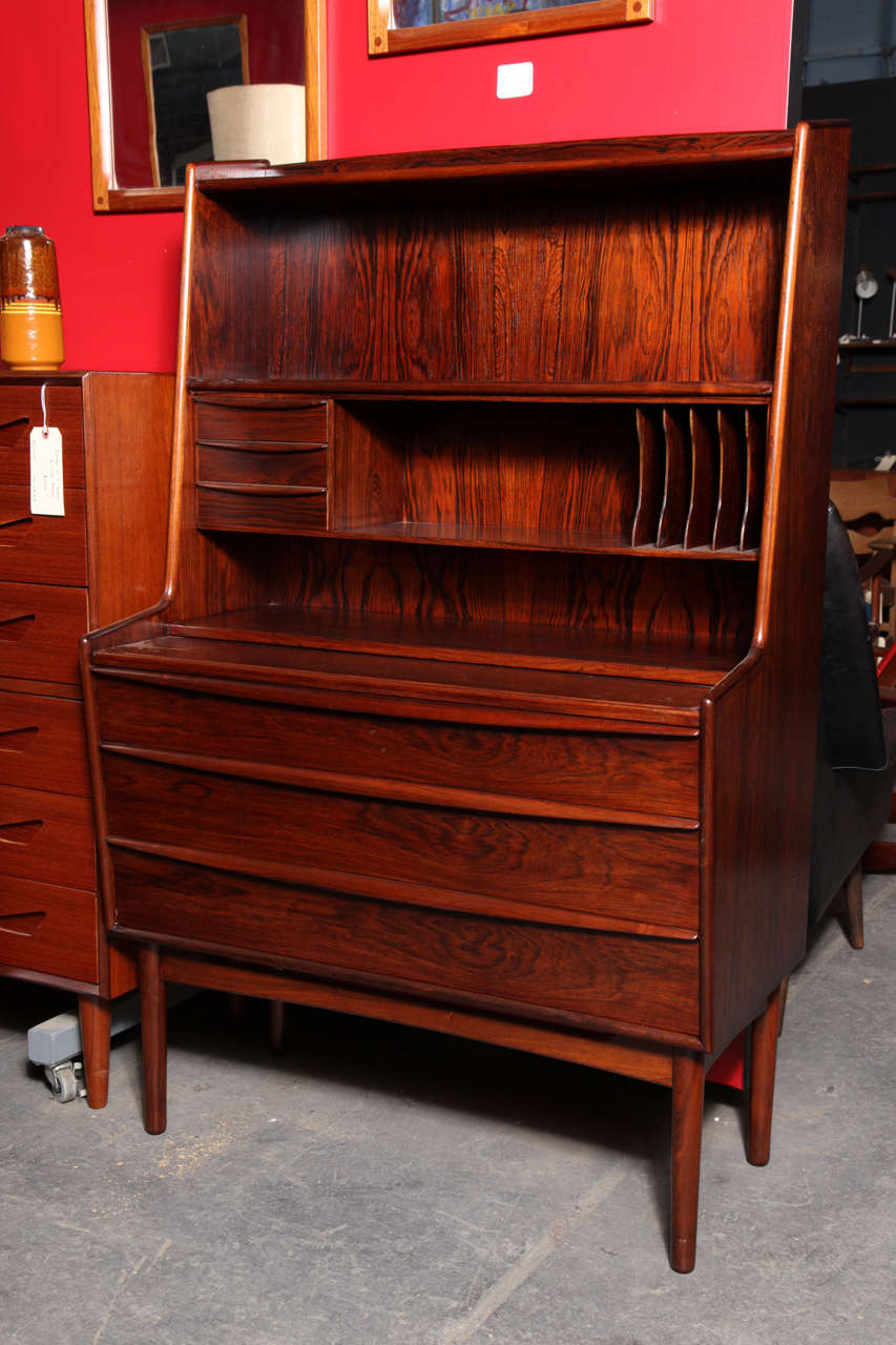 Vintage 1960s Rosewood Writing Desk from Denmark

This Bookshelf / Desk is in excellent, like new condition. These types of secretaries are great because you get all the benefits of a desk, 3 large drawers, and a bookshelf all within the width of