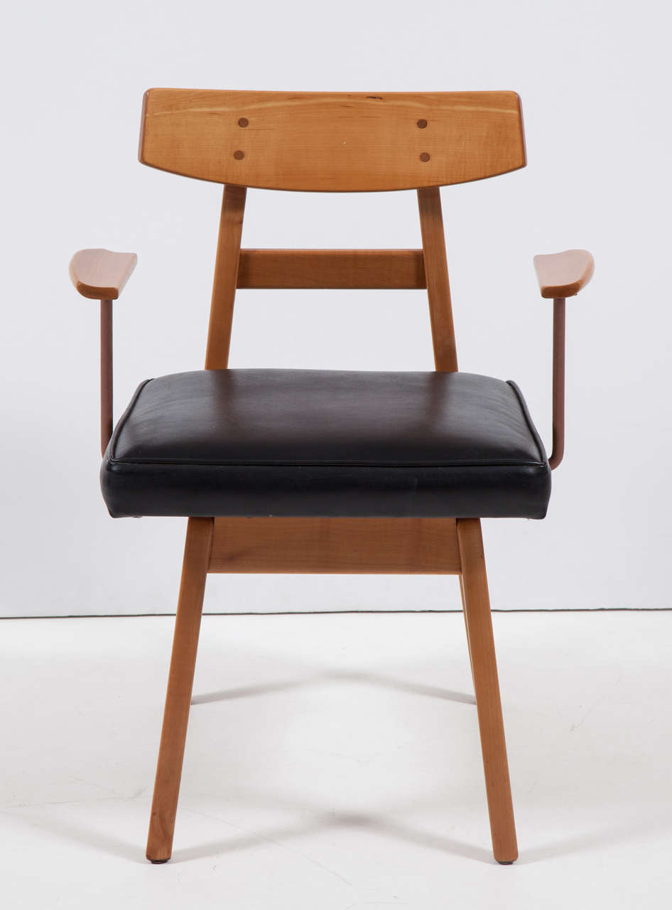Very unusual execution of an iconic armless chair design in maple by Risom with shaped wood arms supported by iron rods covered in pink leather, late 1950s. Newly refinished, otherwise original, retaining original black Naugahyde seat, which shows