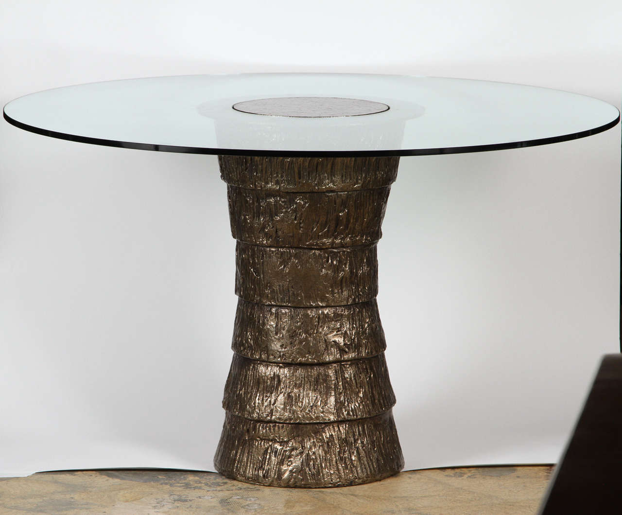 A contemporary, Brutalist, organic modern sculptural steel pedestal style small dining or center table with glass top. Gold textured bronze finish. By order.